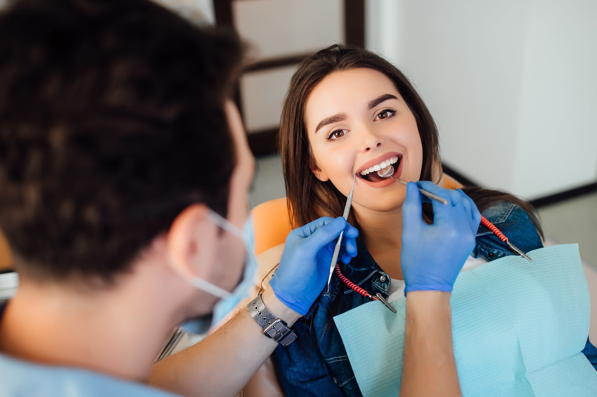 Dentista realizando revisión dental a paciente sonriente en clínica de implantología